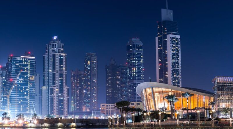 Stunning view of Dubai's illuminated skyline with modern skyscrapers reflecting on water at night.